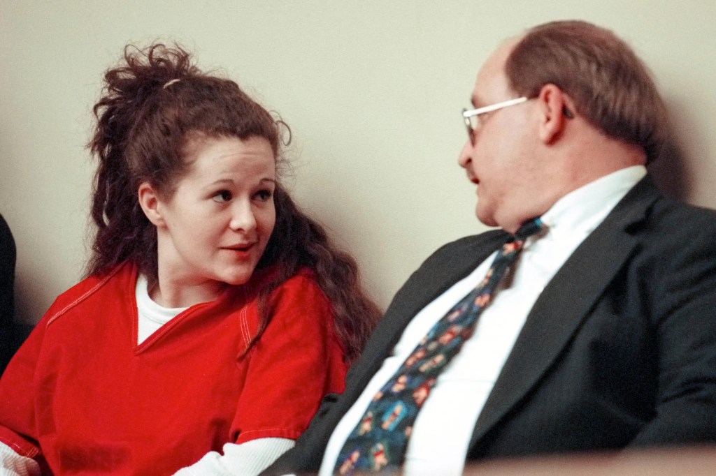 Christa Gail Pike, in a red jumpsuit, confers with her attorney, William C. Talman.